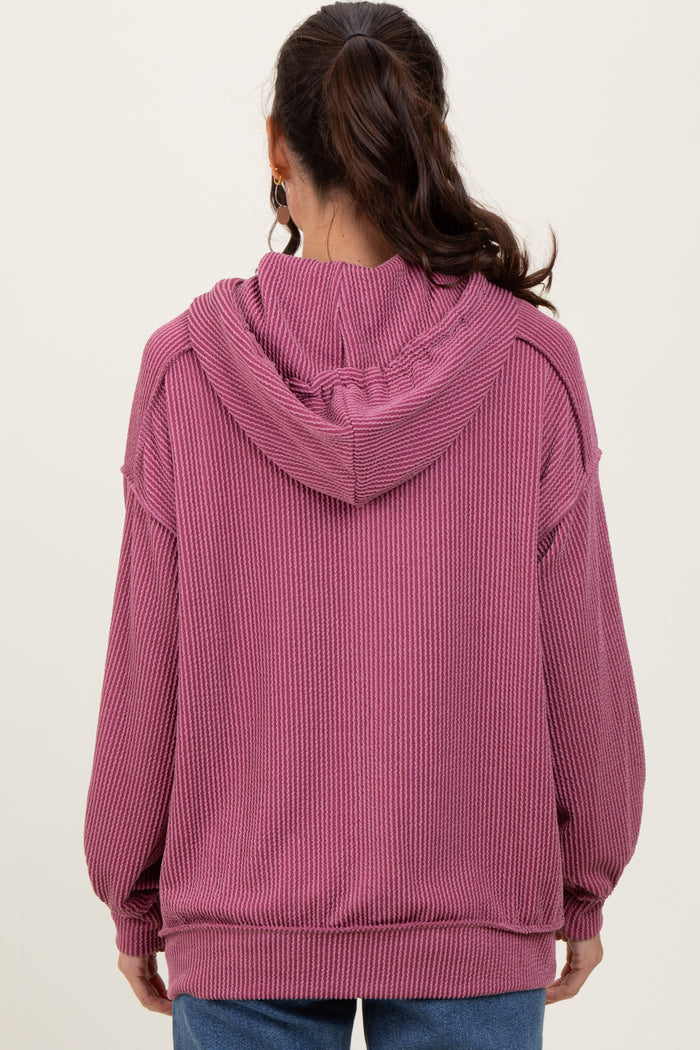woman wearing a cozy mauve oversized hooded sweatshirt with ribbed texture viewed from the back