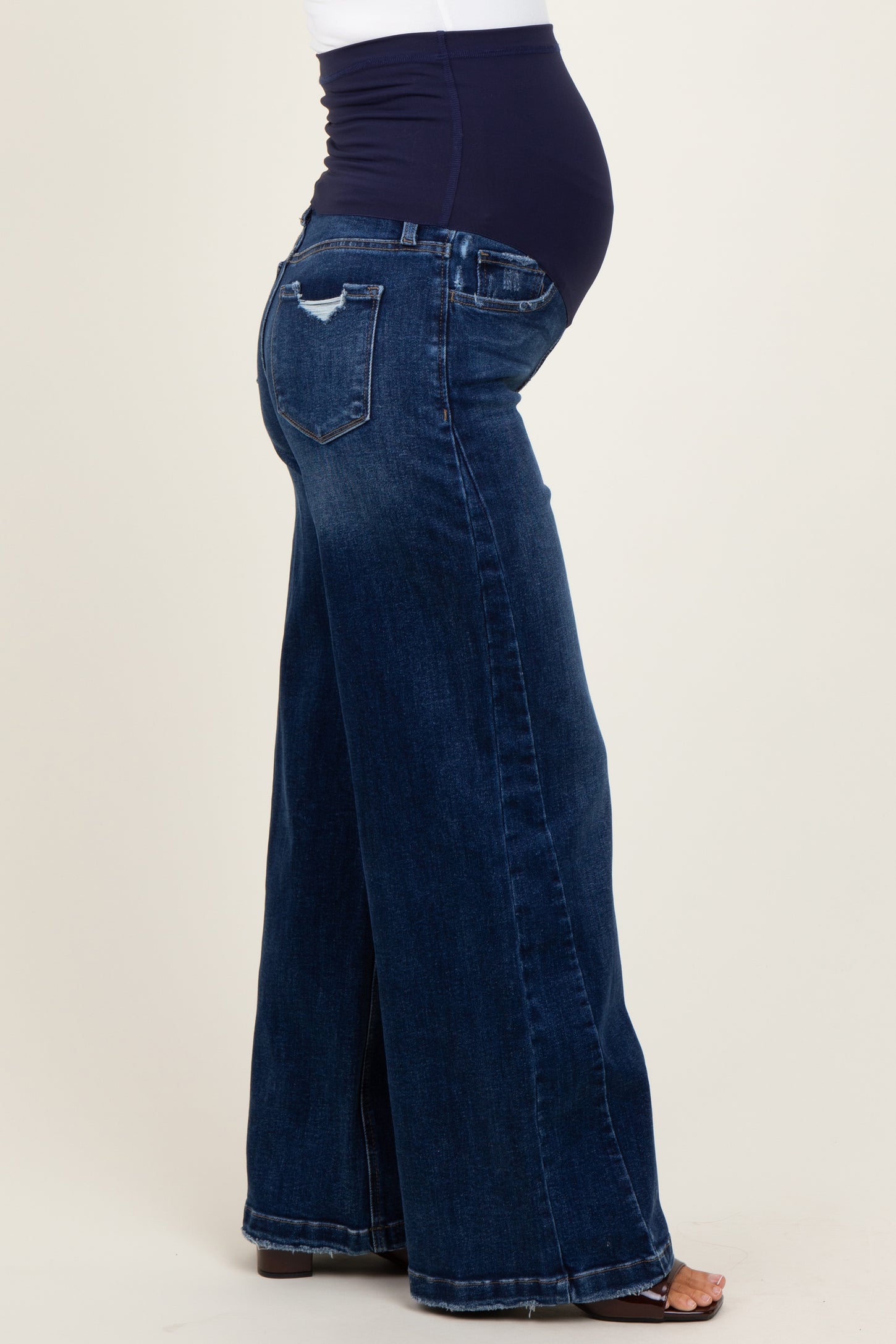 maternity wear featuring wide leg dark blue jeans with a supportive waistband and a visible baby bump