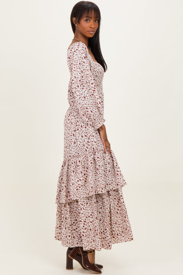 woman wearing a floral print long sleeve maxi dress with tiered ruffles and a fitted bodice