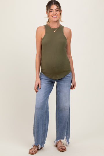 woman wearing an olive green ribbed maternity tank top and light blue distressed jeans, showing her baby bump