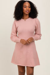 woman wearing a light pink long sleeve sweater dress with a v-neck and puffed sleeves