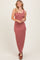 woman wearing a striped burgundy maxi dress with a button-up front and a fitted silhouette