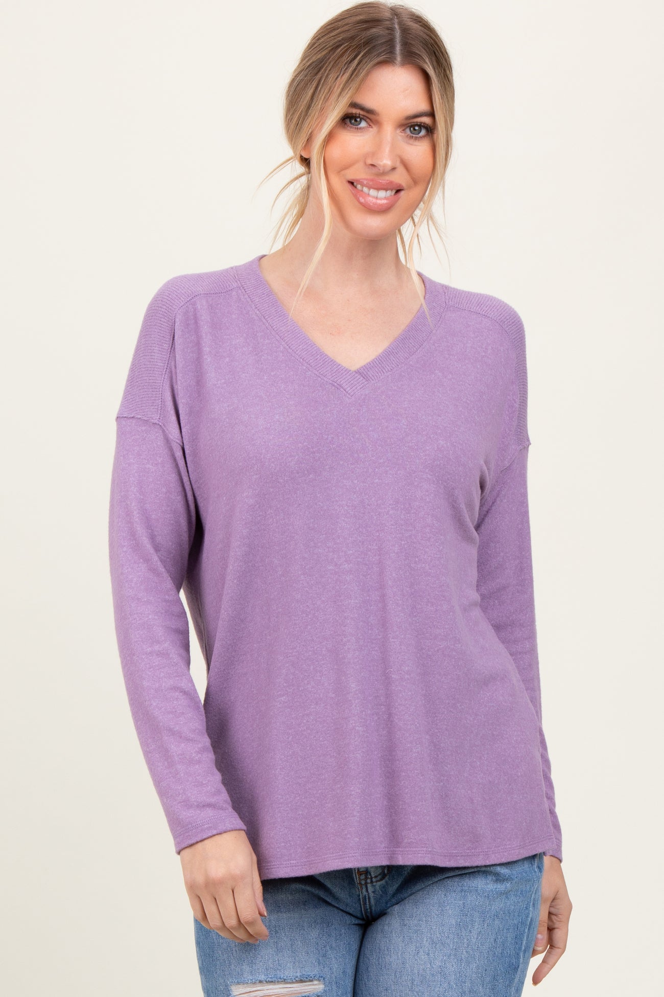woman wearing a light purple long sleeve v-neck top with a relaxed fit and slouchy shoulders