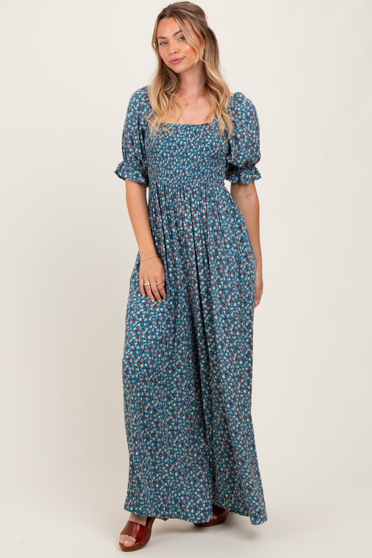 woman wearing a blue floral maxi dress with puff sleeves and a square neckline