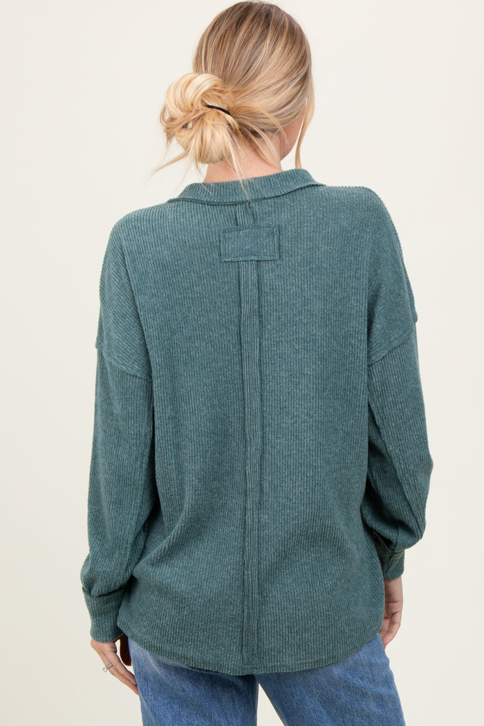 woman wearing a green ribbed long sleeve button-up shirt, seen from the back