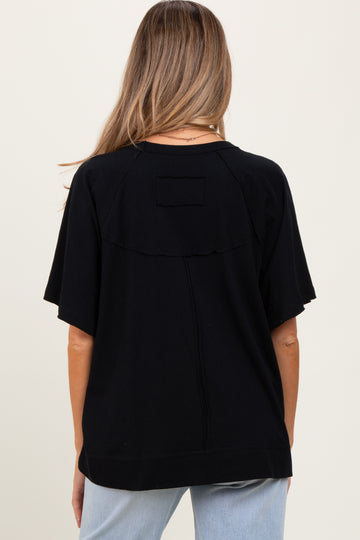 woman wearing a black relaxed fit maternity top with short sleeves and a back flap detail