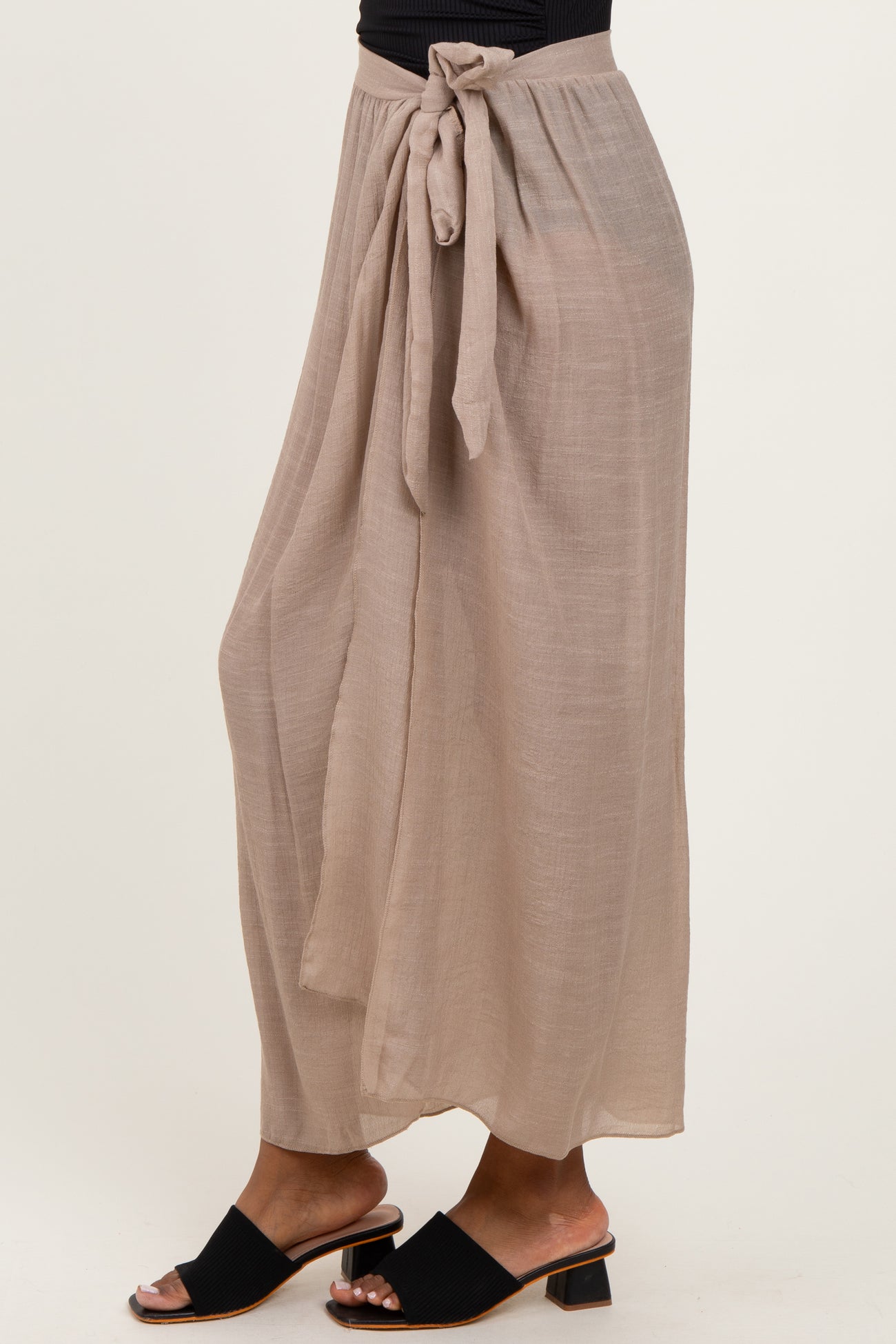 woman wearing a beige flowy maxi skirt with a tied waist and sandals