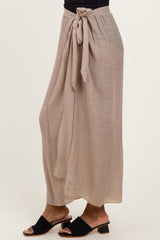 woman wearing a beige flowy maxi skirt with a tied waist and sandals