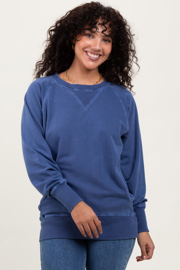 woman wearing a blue casual sweatshirt with a relaxed fit and ribbed hem, smiling at the camera