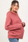 woman wearing a pink maternity hoodie with cable knit sleeves and a visible baby bump