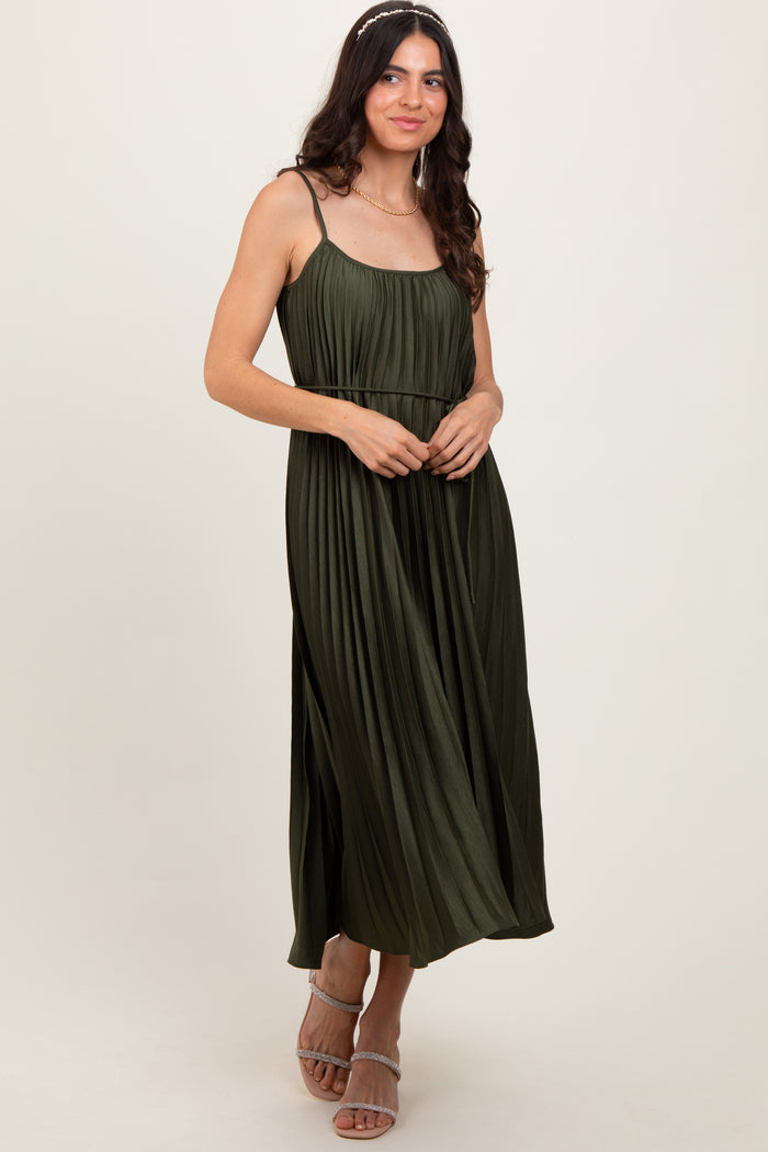 woman wearing a dark olive green pleated maxi dress with spaghetti straps and a flowing silhouette