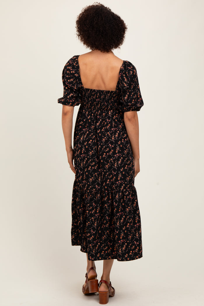 woman wearing a black floral maxi dress with puff sleeves and a smocked back