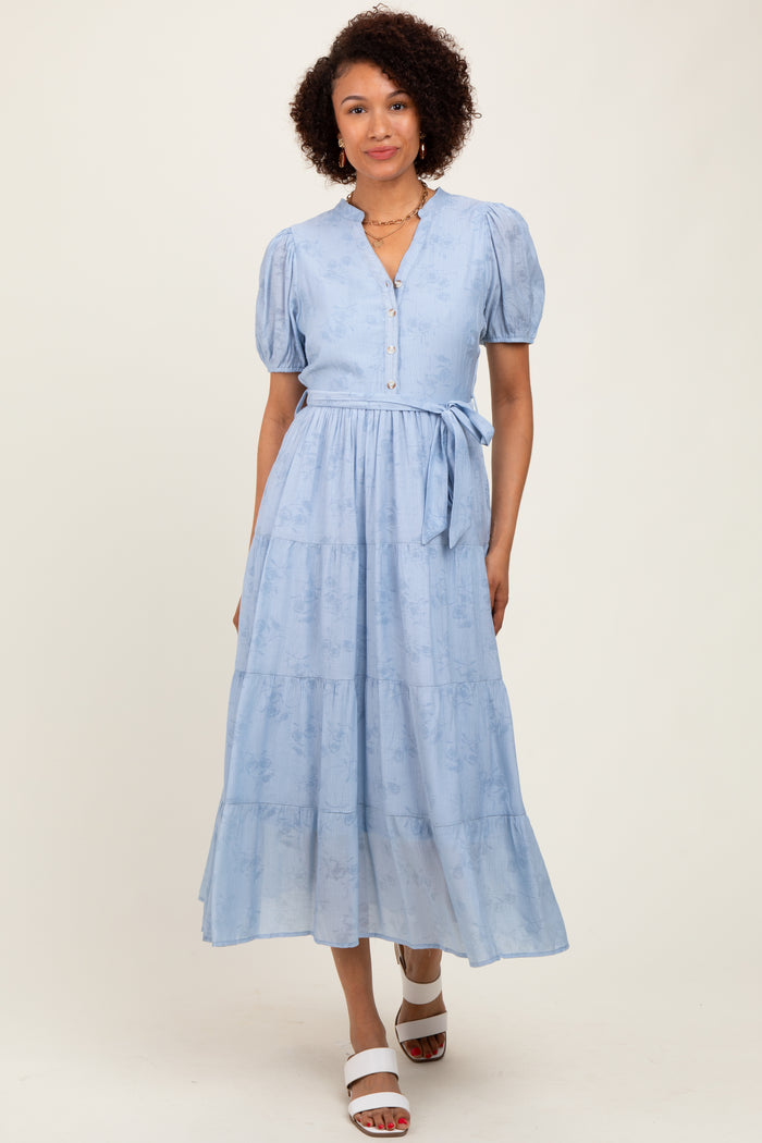 woman wearing a light blue tiered maxi dress with puff sleeves and buttons, styled with white sandals