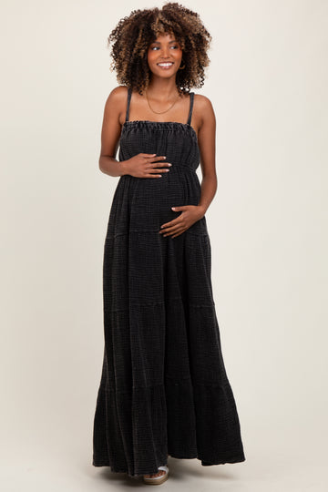 woman wearing a black tiered maxi maternity dress and holding her baby bump