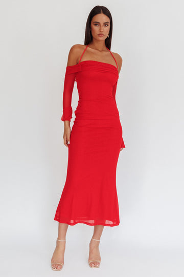 woman wearing a red off-shoulder midi dress with a fitted bodice and flared skirt, standing on a plain background