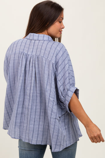 woman wearing a blue and white striped maternity blouse with roll-up sleeves and a loose fit, back view