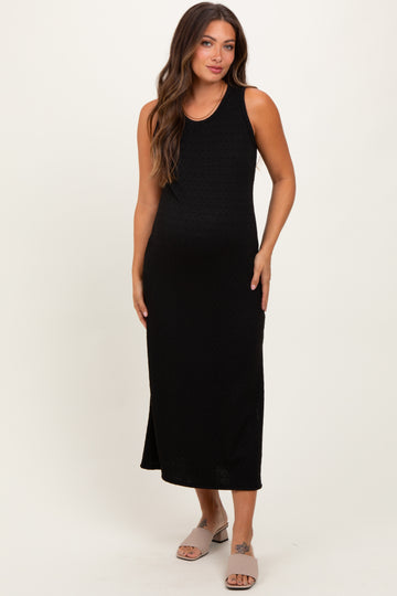 woman wearing a black sleeveless maternity maxi dress and showing her baby bump