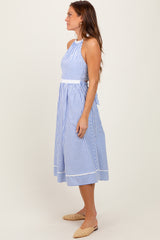 woman wearing a blue and white striped halter neck midi dress with a fitted bodice and a flowing skirt