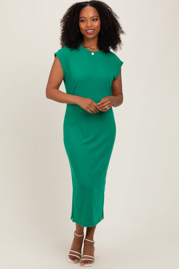 woman wearing a green ribbed midi dress with cap sleeves and side slits, standing and smiling