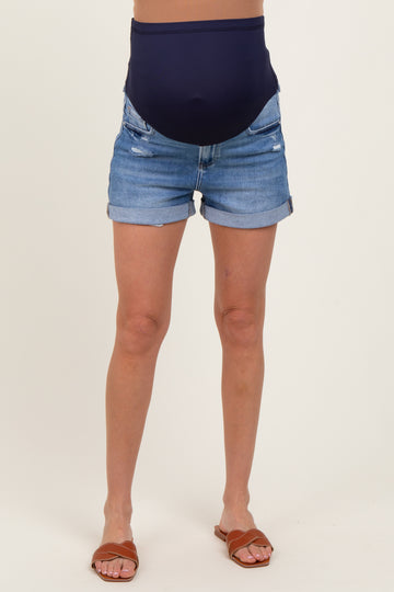 woman wearing a pair of distressed denim maternity shorts with a navy blue belly support band