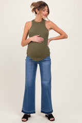 woman wearing an olive green ribbed maternity tank top and blue flared jeans, highlighting her baby bump