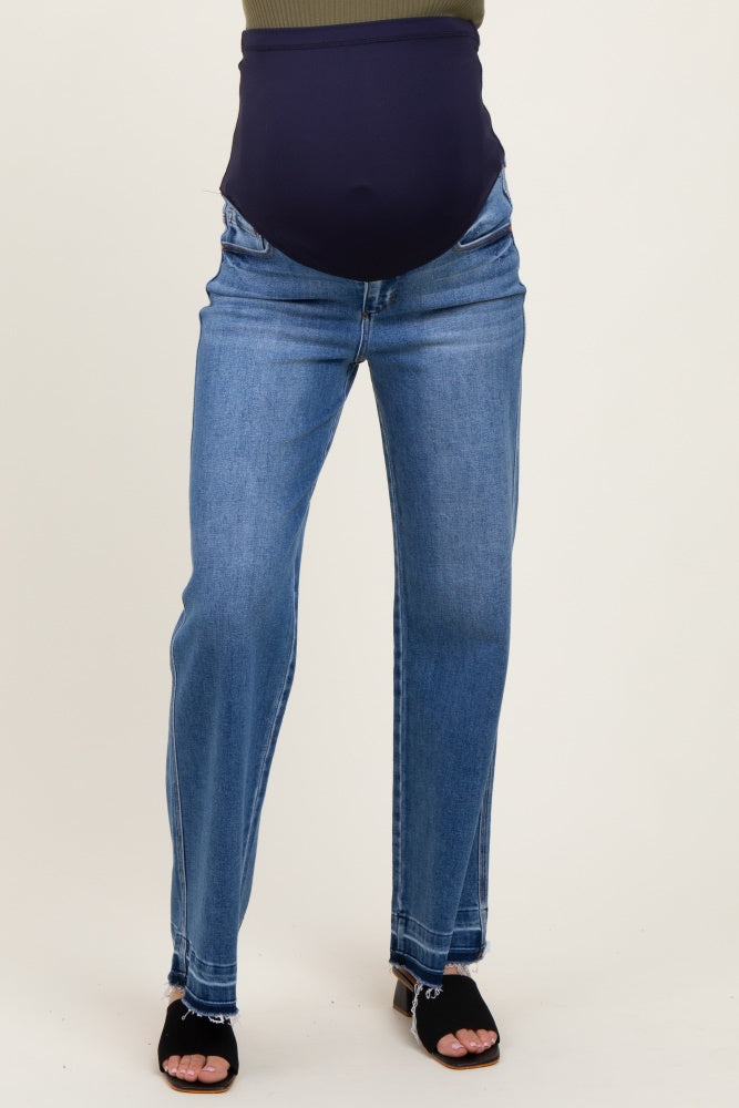woman wearing light blue maternity jeans with a navy blue over-the-bump waistband and open-toe black heels
