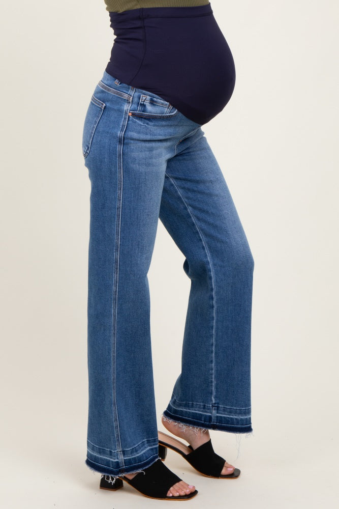woman wearing a pair of dark blue wide-leg maternity jeans with a supportive belly panel and a visible baby bump