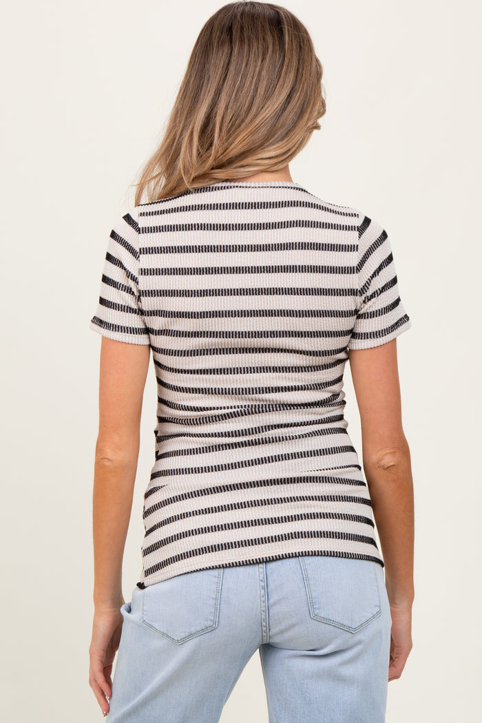 woman wearing a striped maternity top in beige and black, showcasing a fitted style and round neckline, with back view shown