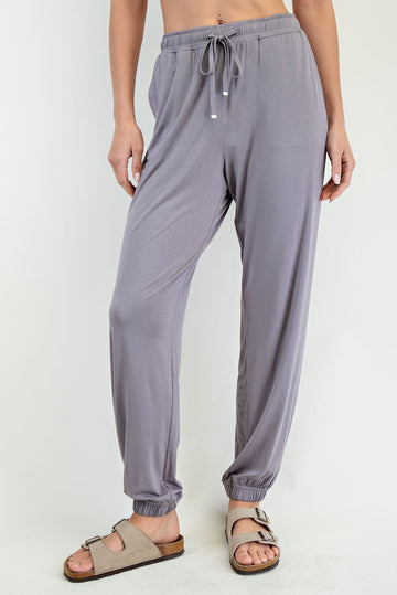 woman wearing light gray relaxed fit jogger pants with an elastic waistband and cuffed ankles