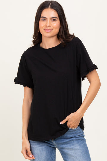 woman wearing a black short sleeve t-shirt with ruffle details on sleeves and styled with light blue jeans