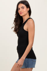 woman wearing a fitted black ribbed tank top paired with denim shorts