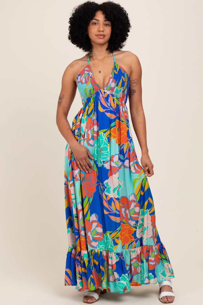 woman wearing a colorful floral maxi dress with a halter neckline and ruffled hemline