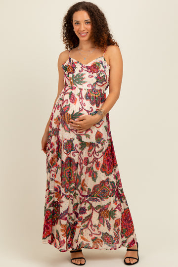 woman wearing a floral print maternity maxi dress with spaghetti straps and a visible baby bump