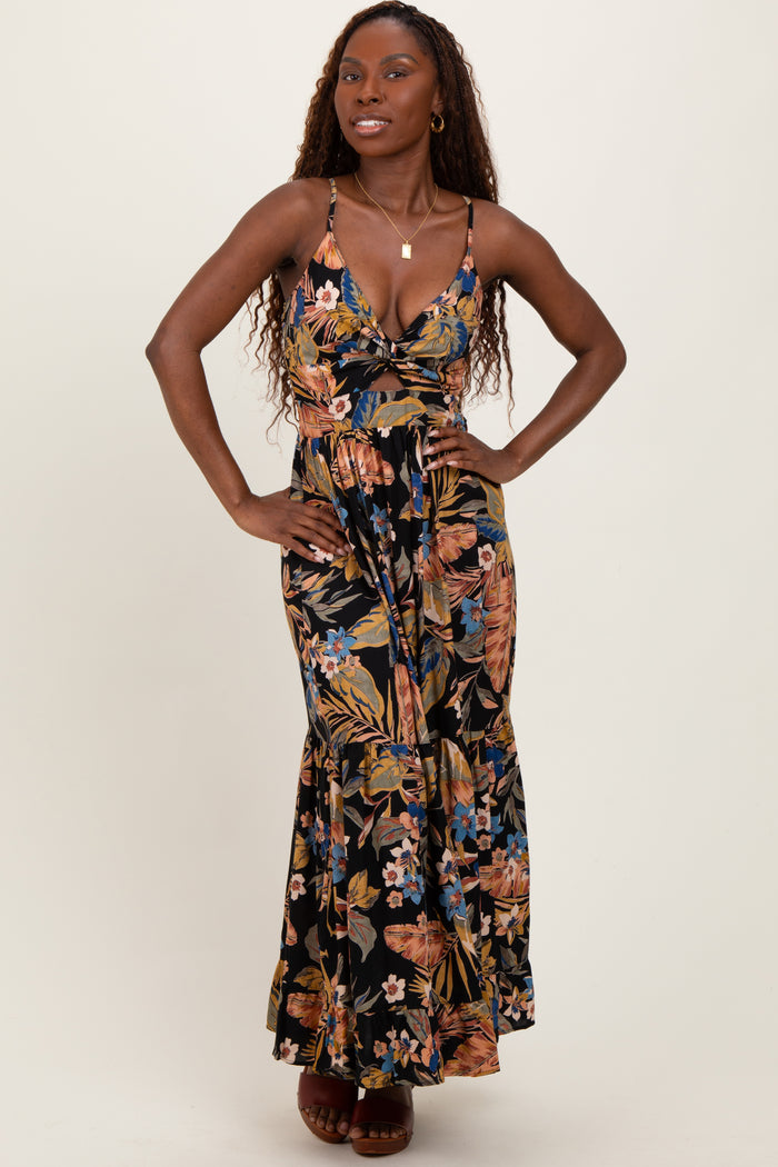 woman wearing a floral maxi dress with a deep neckline and spaghetti straps, posing with her hands on her hips