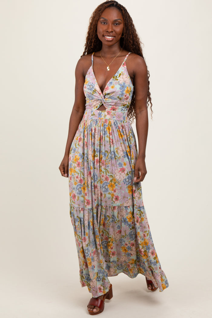 woman wearing a floral maxi dress with a deep v-neck and tiered skirt, posing against a neutral background