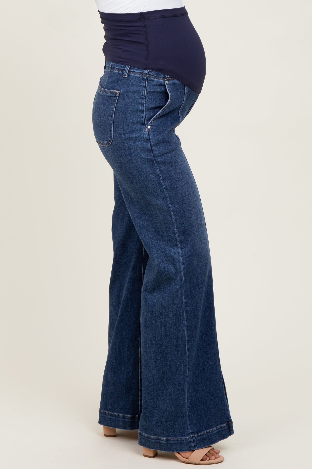 woman wearing dark blue maternity wide-leg jeans with a supportive belly panel and visible baby bump