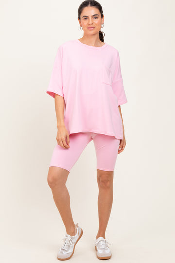 woman wearing a pink oversized t-shirt with a pocket and matching pink bike shorts