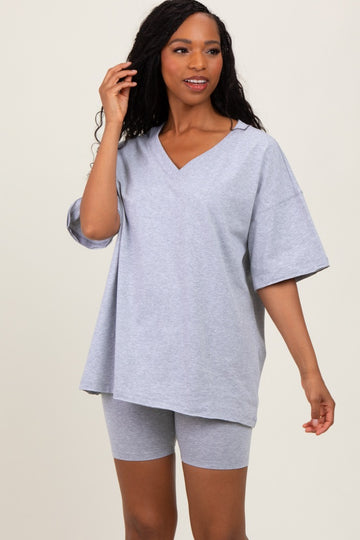 woman wearing a light gray oversized v-neck t-shirt and matching bike shorts