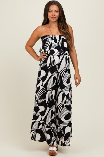 woman wearing a black and white patterned maternity maxi dress with a ruffled neckline and wide leg style