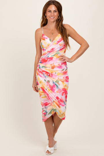 woman wearing a floral print midi dress with a wrap design and adjustable spaghetti straps