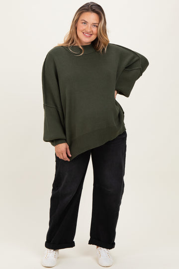 woman wearing an oversized dark green maternity sweater with a relaxed fit and black wide-leg pants