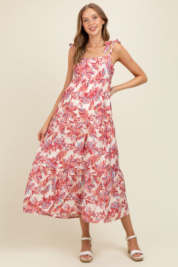 woman wearing a pink floral maternity maxi dress with tie straps and a flowy skirt