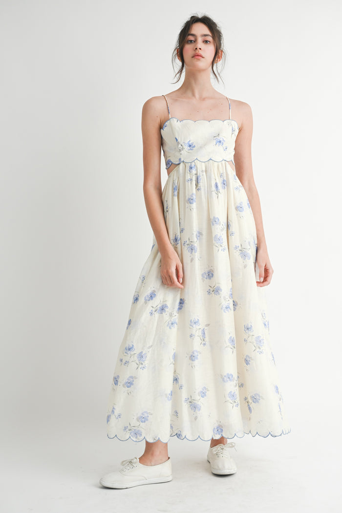 woman wearing a floral print maxi dress with spaghetti straps and a scalloped neckline