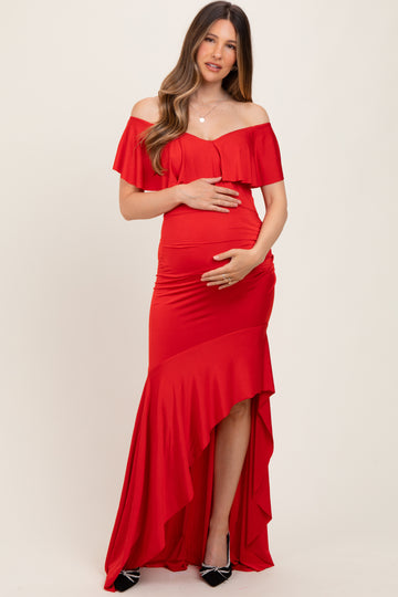 woman wearing a red off-the-shoulder maternity dress with a high-low hemline and holding her baby bump