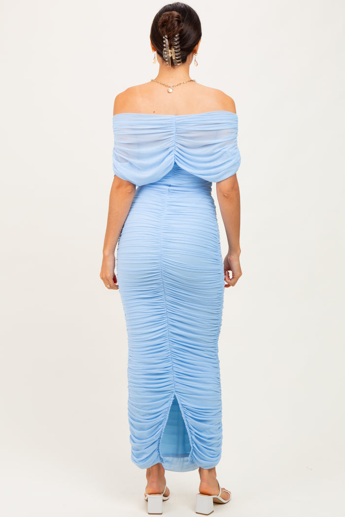 woman wearing a light blue off-the-shoulder ruched maxi dress with a back slit and flowing sleeves