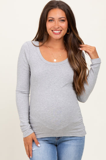 woman wearing a gray long sleeve maternity top with a scoop neckline and a visible baby bump