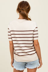 woman wearing a cream and brown striped short sleeve sweater with a relaxed fit and styled with denim shorts
