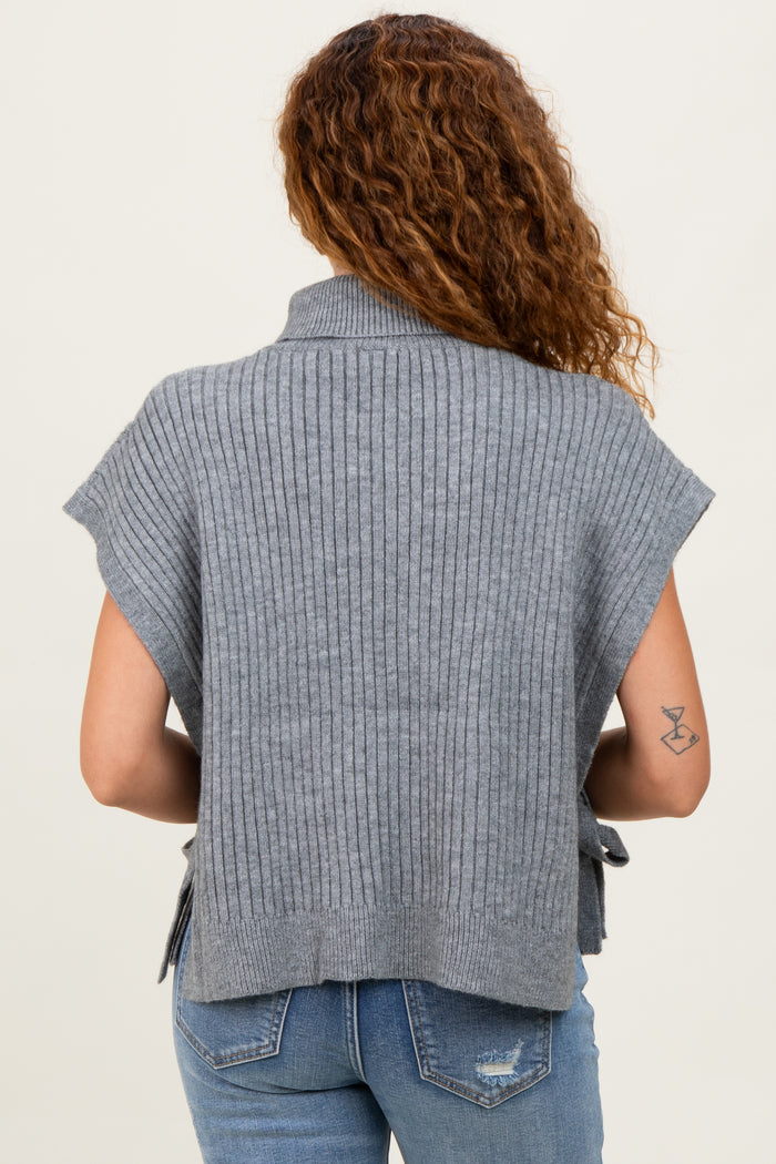 woman wearing a gray ribbed sweater top with short sleeves and open sides, seen from the back