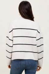 woman wearing a cream striped oversized sweater with black stripes, paired with blue jeans, view from the back