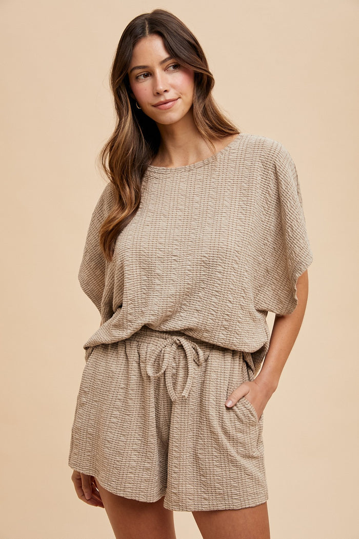 woman wearing a light brown textured knit short set with a relaxed fit and drawstring waist